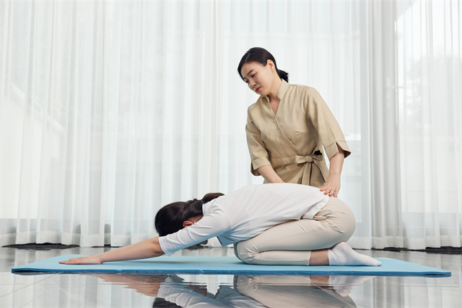 摄图网_502383656_月嫂帮助产妇做产后护理瑜伽（企业商用）.jpg